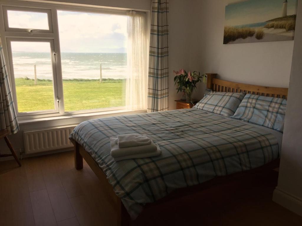 a bedroom with a bed and a large window at O'Neill's Bed&Breakfast in Ballyheigue