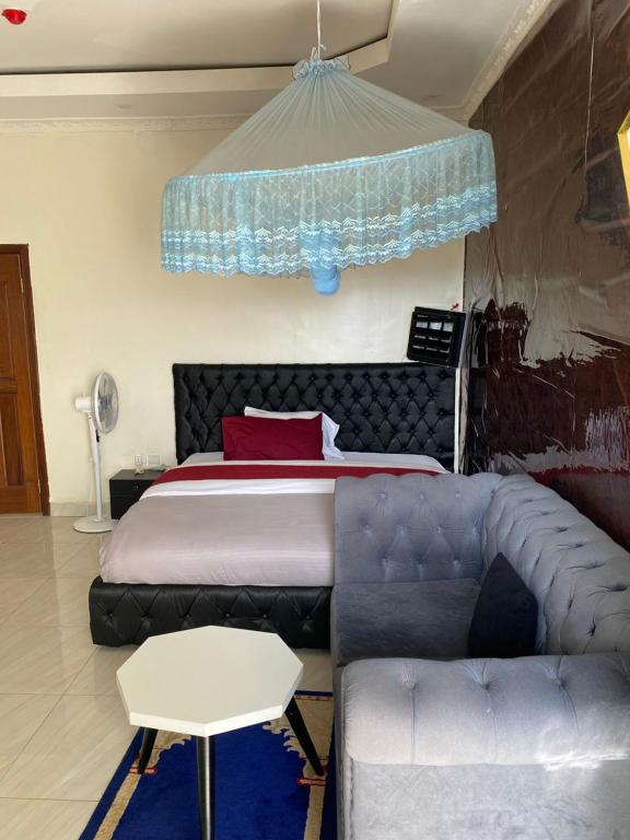 a bedroom with a bed and a couch next to a bed at TWIGER HOUSE by WILSON in Kigali