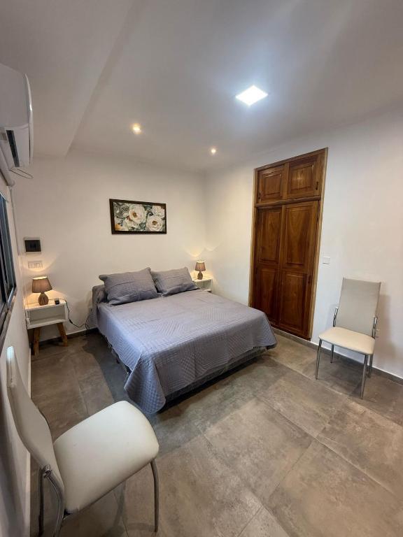 a bedroom with a bed and two chairs in it at Emperatriz I in Posadas