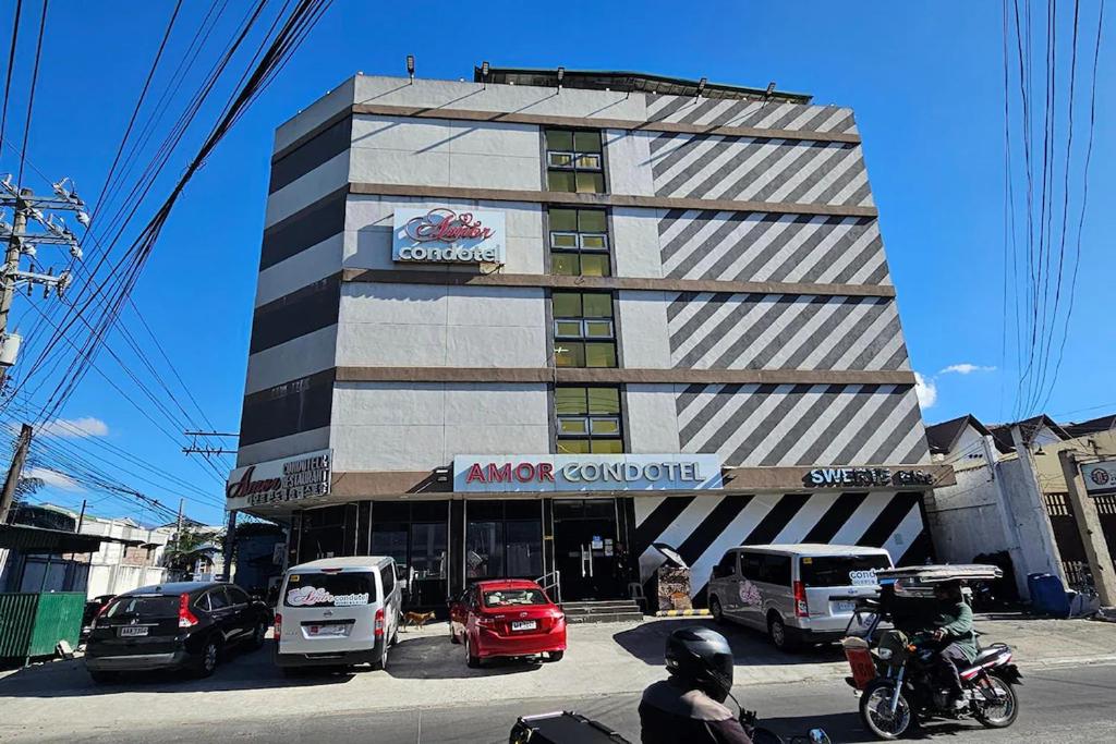 a building with cars parked in front of it at Aimor Condotel in Pampang