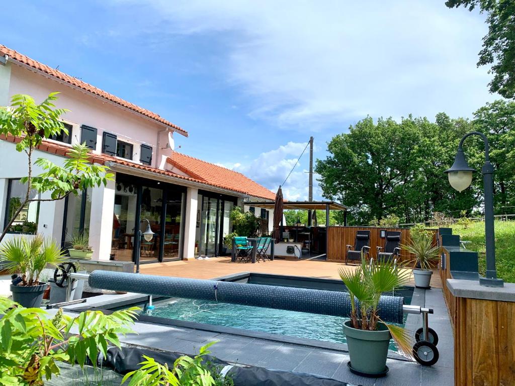 une cour arrière avec une piscine et une maison dans l'établissement Maison de campagne au calme avec piscine, à Labruguière