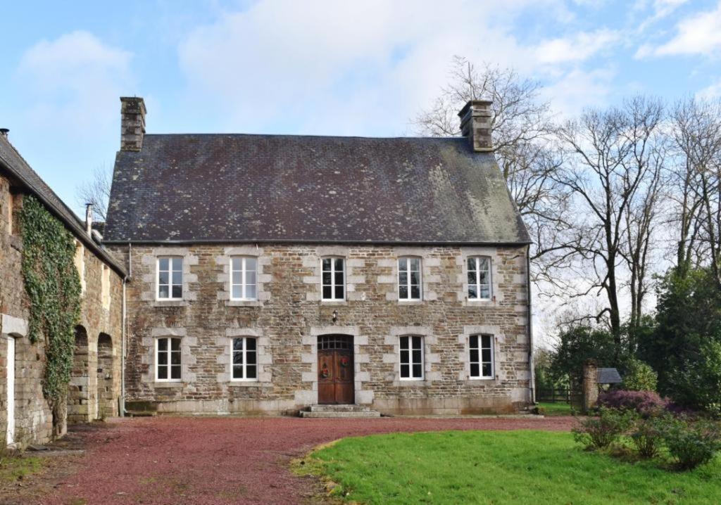 an old stone house with a roof at Country House La Feronnière in Le Mesnil-Amand