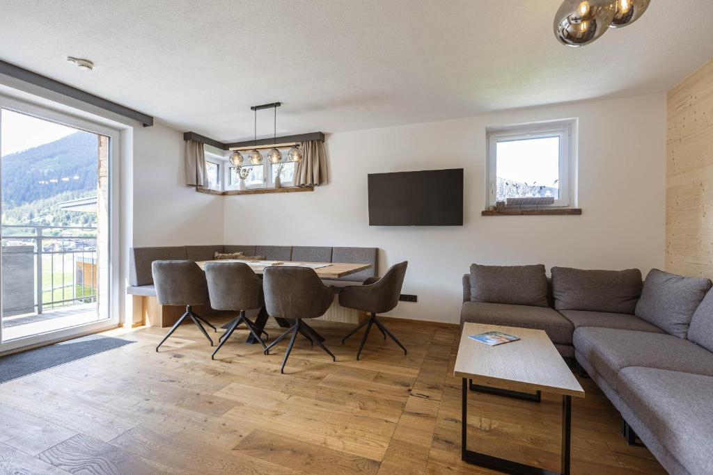 a living room with a couch and a table at Zugspitz Suites Lermoos by ALPS RESORTS in Lermoos