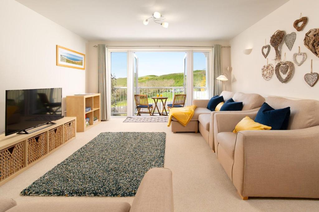 a living room with a couch and a television at 6 Bluestone Point in Mortehoe