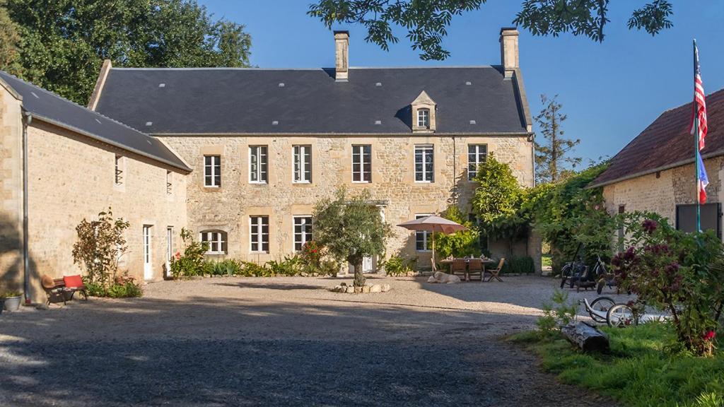 un grand bâtiment en briques avec un drapeau devant lui dans l'établissement La Cour Souveraine - Chambre d'hôtes Le Cap, à Mosles