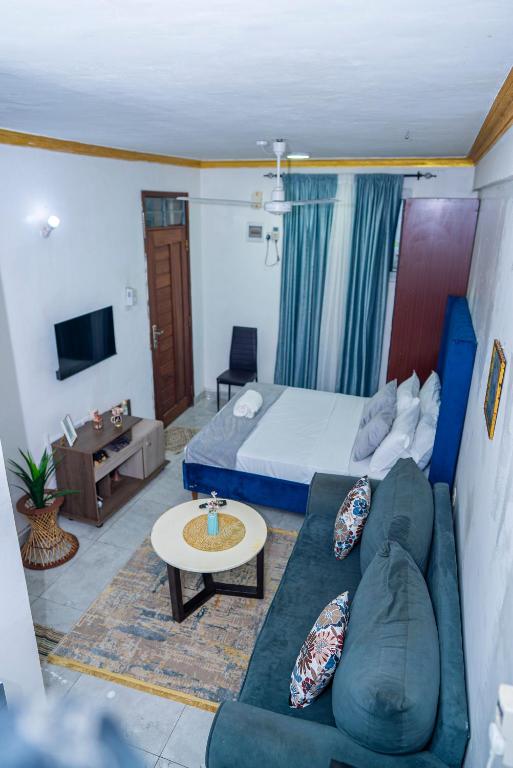 a living room with a couch and a bed at Nayas Haven Studio2 in Mombasa Bamburi Mtambo Mwembeni with hot shower in Mombasa