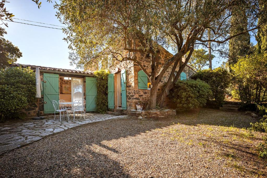 una casa verde con tavolo e sedie in un cortile di Domaine de l'Auribelle - Villa Tempora a Pézenas