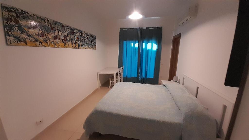 a small room with a bed and a window at Bilocale Su Lizzu de Erminia in La Caletta