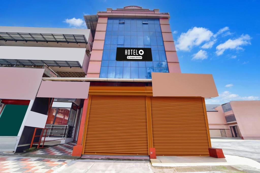 a building with a mlite garage in front of it at Super Hotel O Aluva Town in Cochin