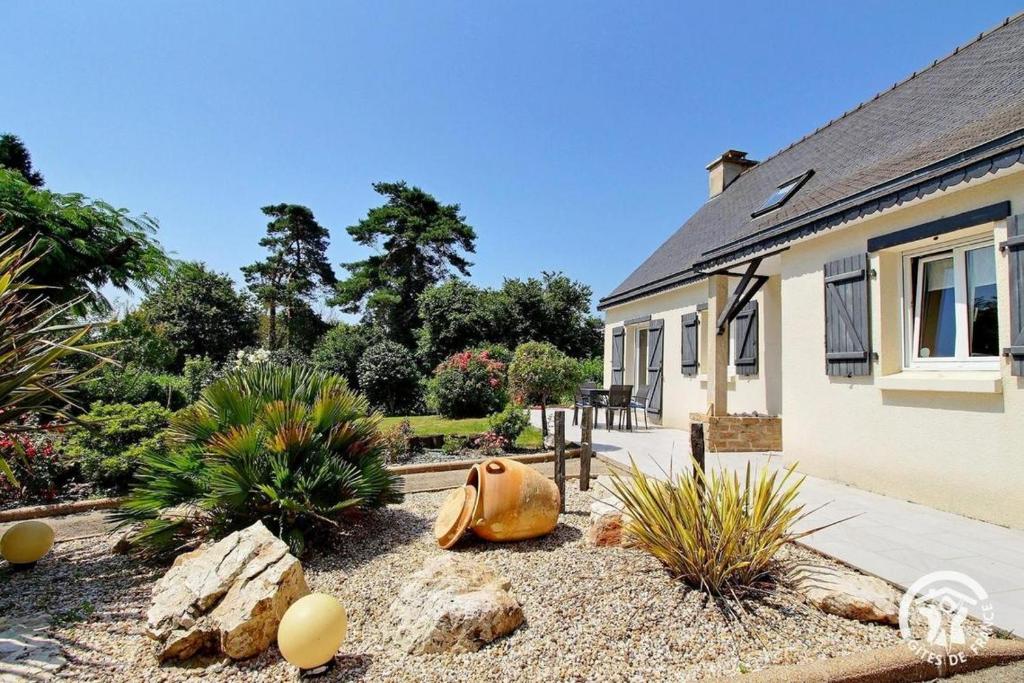un jardin avec une maison avec une citrouille et des plantes dans l'établissement Cocon Breton, à Marzan