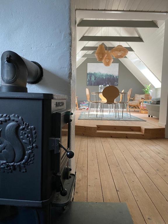 a living room with a stove and a dining room at Cozy big apartment in Blokhus