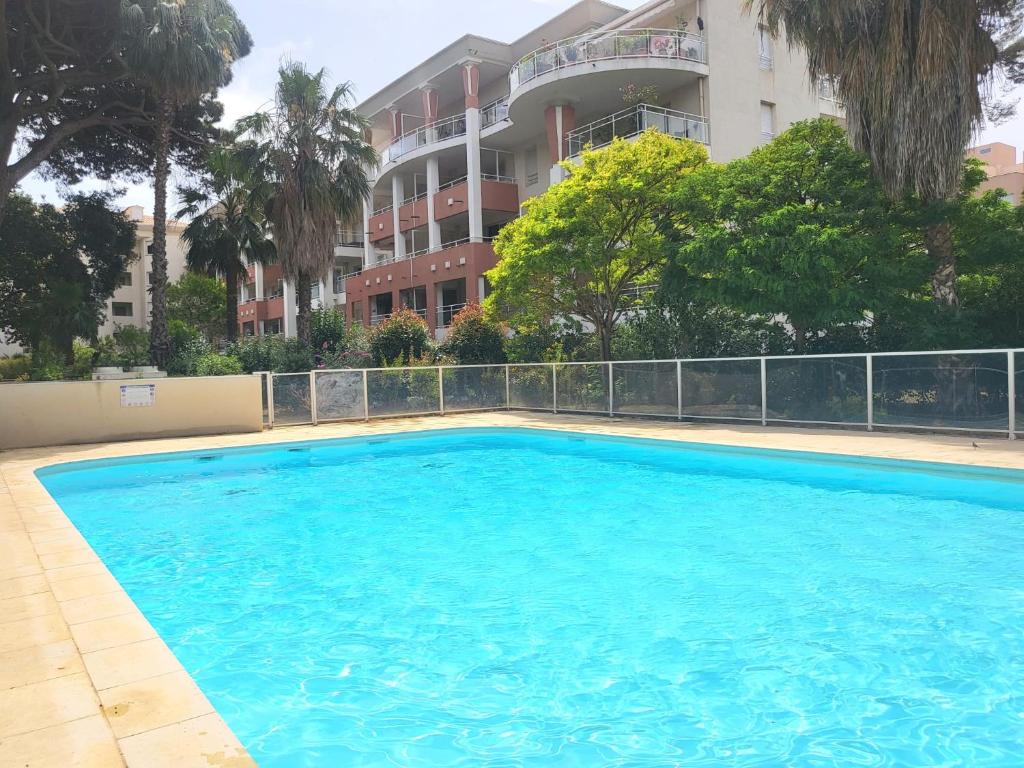 イエールにあるt3, vue mer,piscine, garageの建物の前の大きなプール