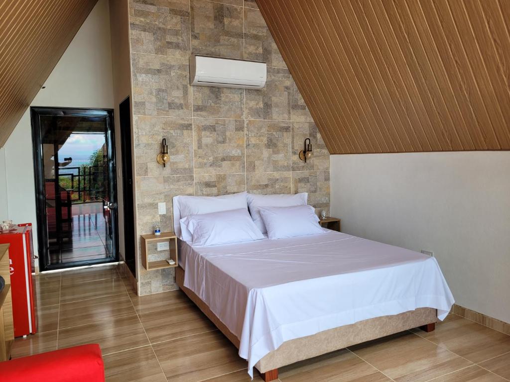 a bedroom with a bed with white sheets and pillows at Villa Victoria Campestre in Rivera