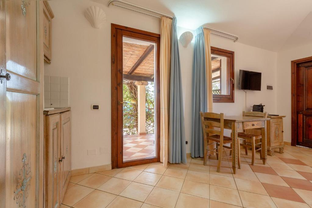 a kitchen and dining room with a table and a door at Porto Giunco Residence in Villasimius