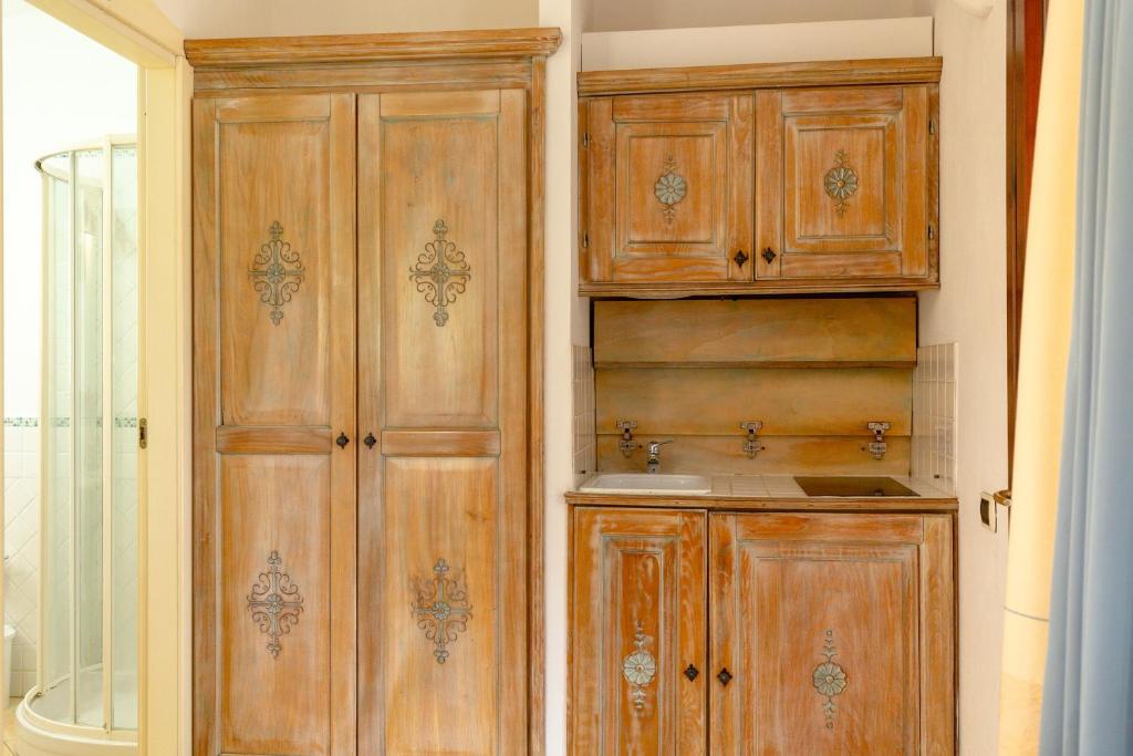 a kitchen with wooden cabinets in a room at Porto Giunco Residence in Villasimius