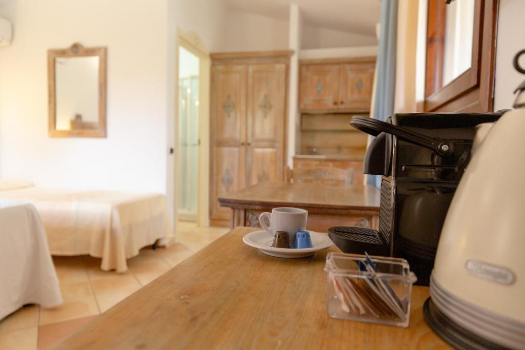 a living room with a bed and a coffee maker at Porto Giunco Residence in Villasimius