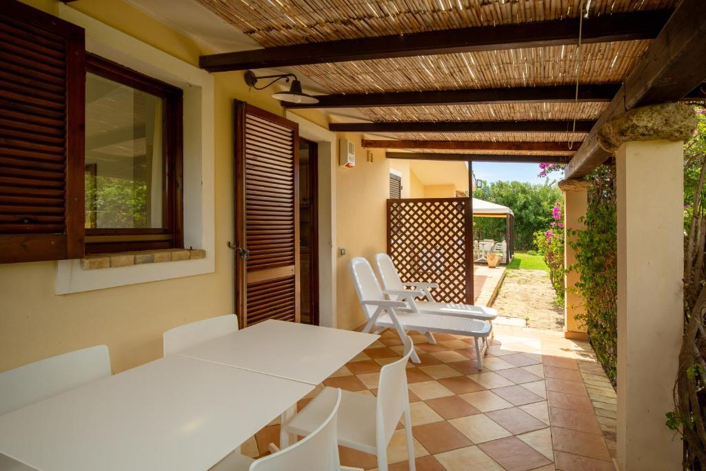 a dining room with a table and chairs on a patio at Porto Giunco Residence in Villasimius