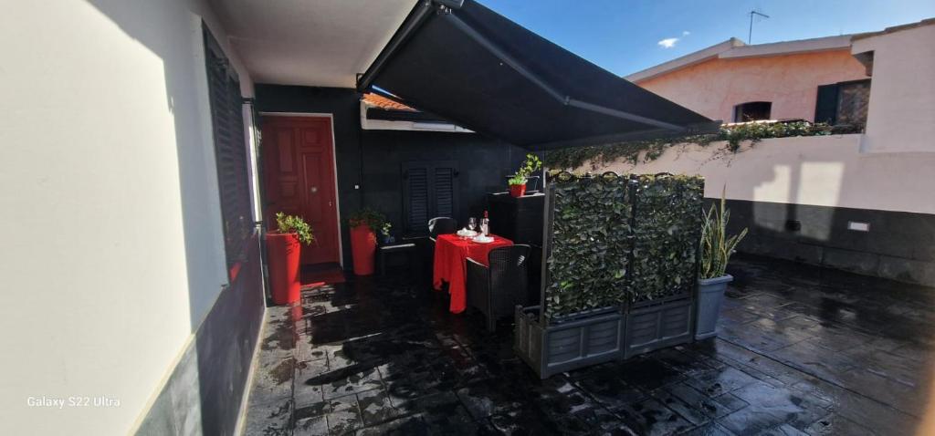 un piccolo cortile con un tavolo rosso e una porta rossa di Appartamento Camilla a Siniscola