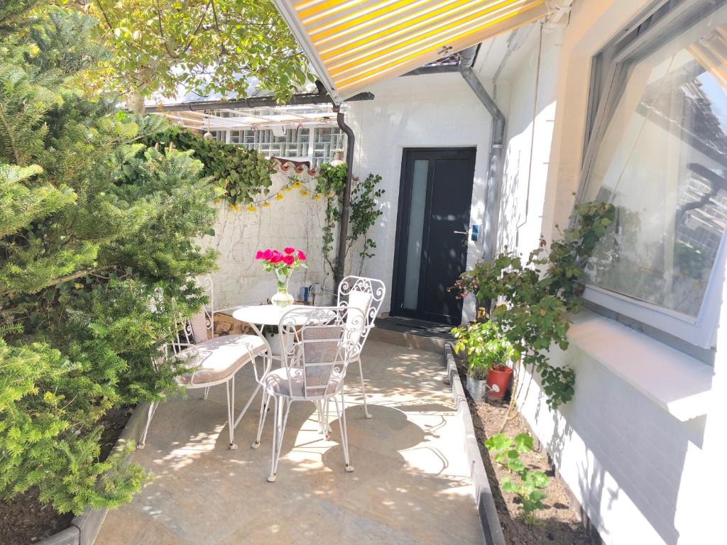 a patio with a table and chairs on the side of a building at Nordsee Pension in Garding