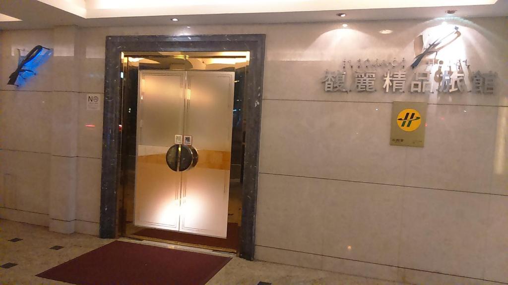 a door in a building with a sign on the wall at Elegance Hotel in Taipei