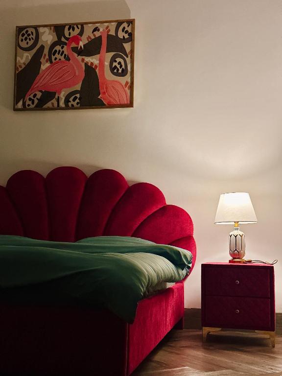 a bedroom with a red bed with a red couch at Thalia Home Măng Đen in Kon Plong