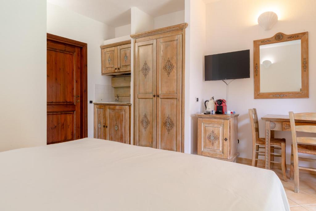 a bedroom with a bed and a table and a mirror at Porto Giunco Residence in Villasimius