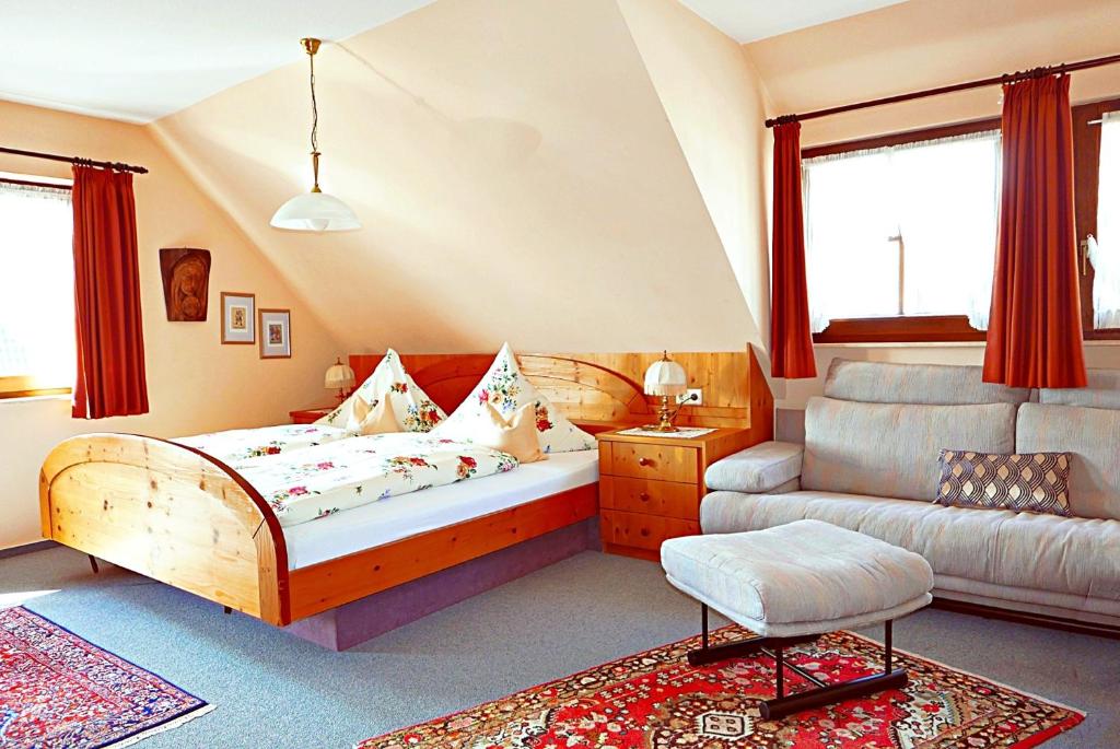 un dormitorio con una cama y un sofá en Landhaus Seiler, en Freudenstadt