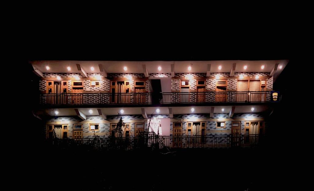 a large building with lights on it at night at Sharaji in Banjār