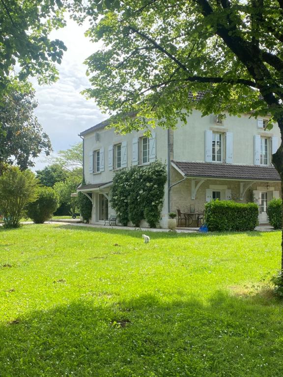 a large white house with a grass yard at Les Suites de Marie-Lot in Vire-sur-Lot