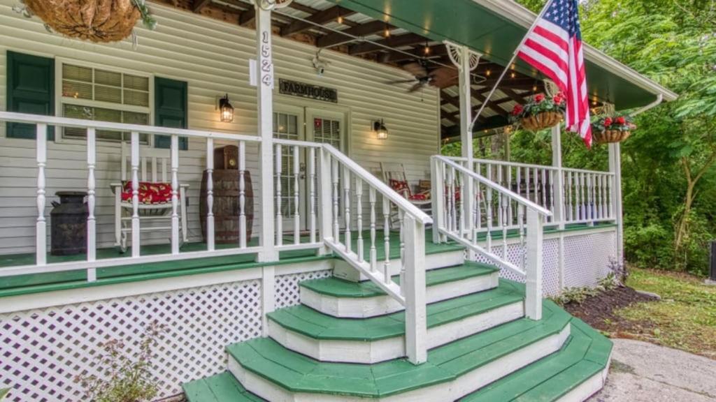 a front porch with green steps and an american flag at The Farmhouse by Avada Properties in Sevierville