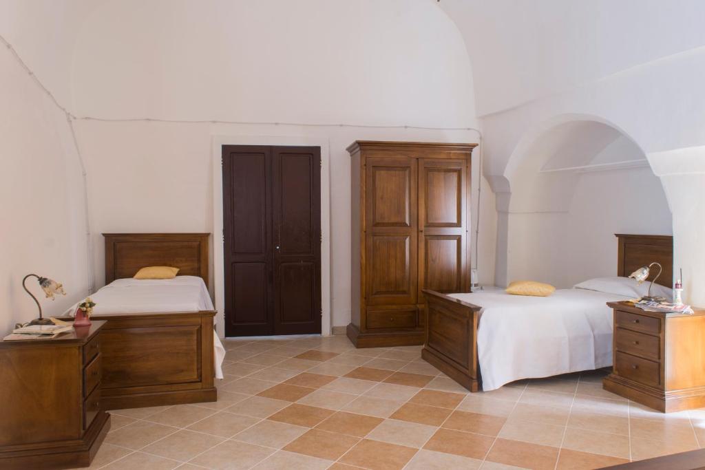 1 dormitorio con 2 camas y armarios de madera en 100 Craste, en Ugento