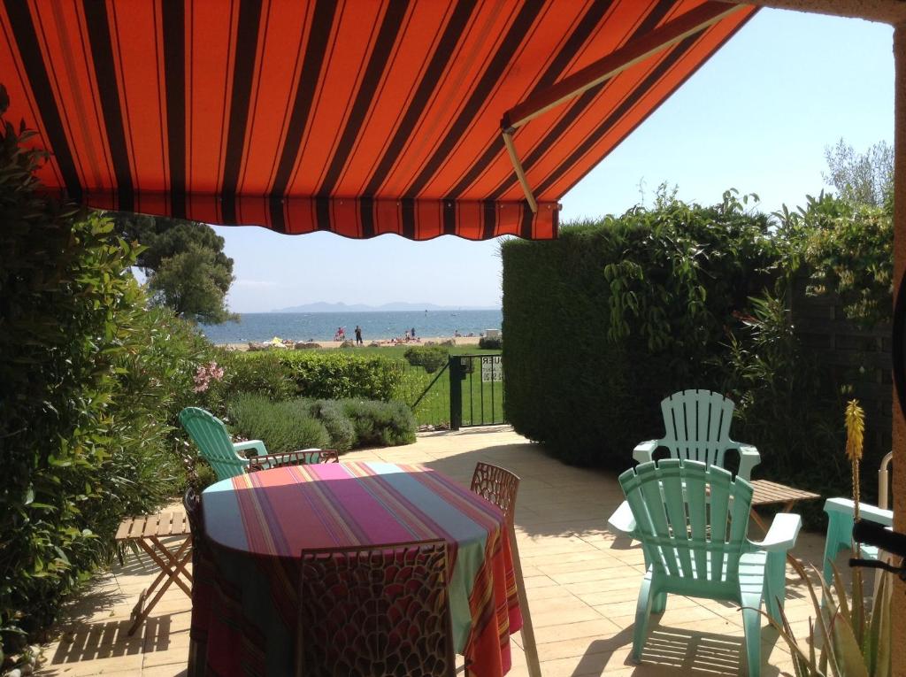 un patio avec une table, des chaises et un parasol dans l'établissement Pieds dans l eau, à La Celle-sous-Gouzon
