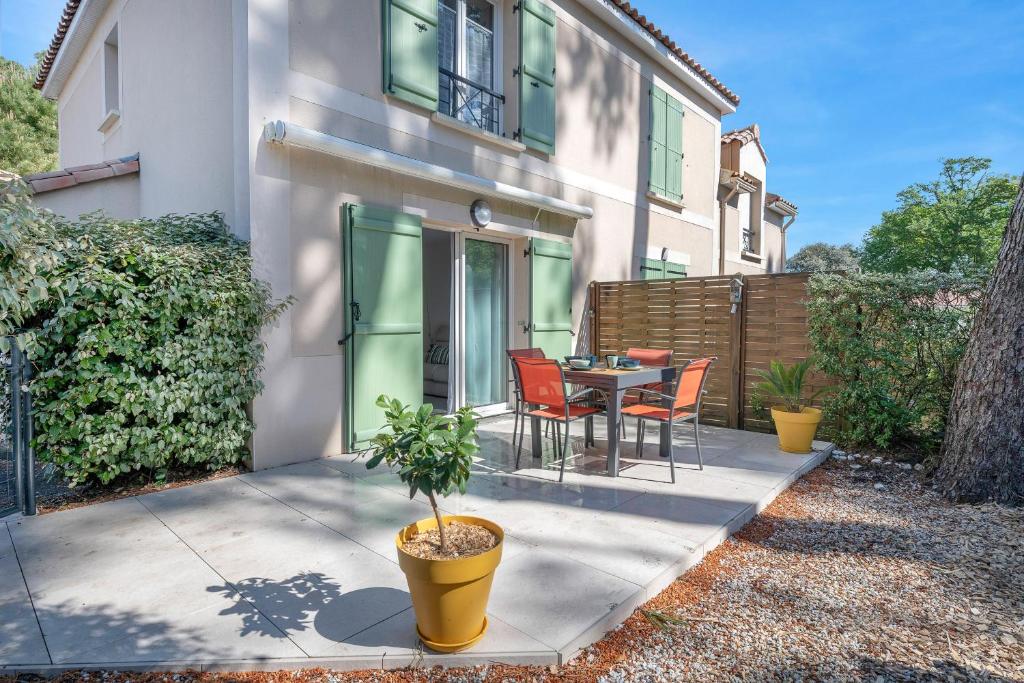 eine Terrasse mit Tisch und Stühlen vor einem Haus in der Unterkunft Maison pour 4 avec terrasse - proche du centre in Saint-Brévin-lʼOcéan