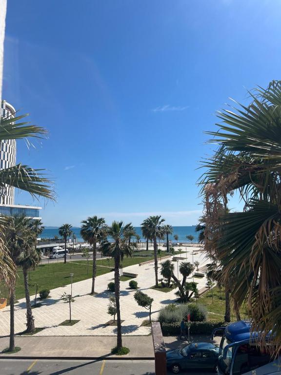 a view of a park with palm trees and the ocean at Sea view Captain Apartment Durres in Durrës