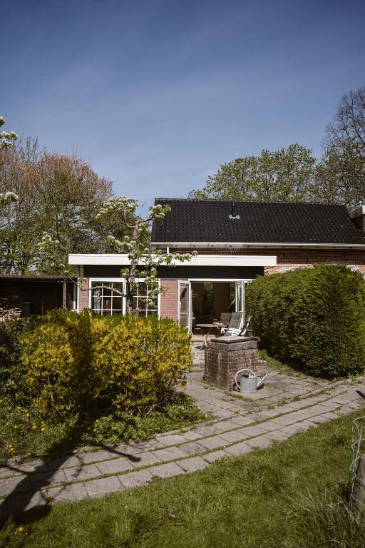 a brick house with a porch and a patio at 't Buitenverblijf, gratis parkeren in Middelburg