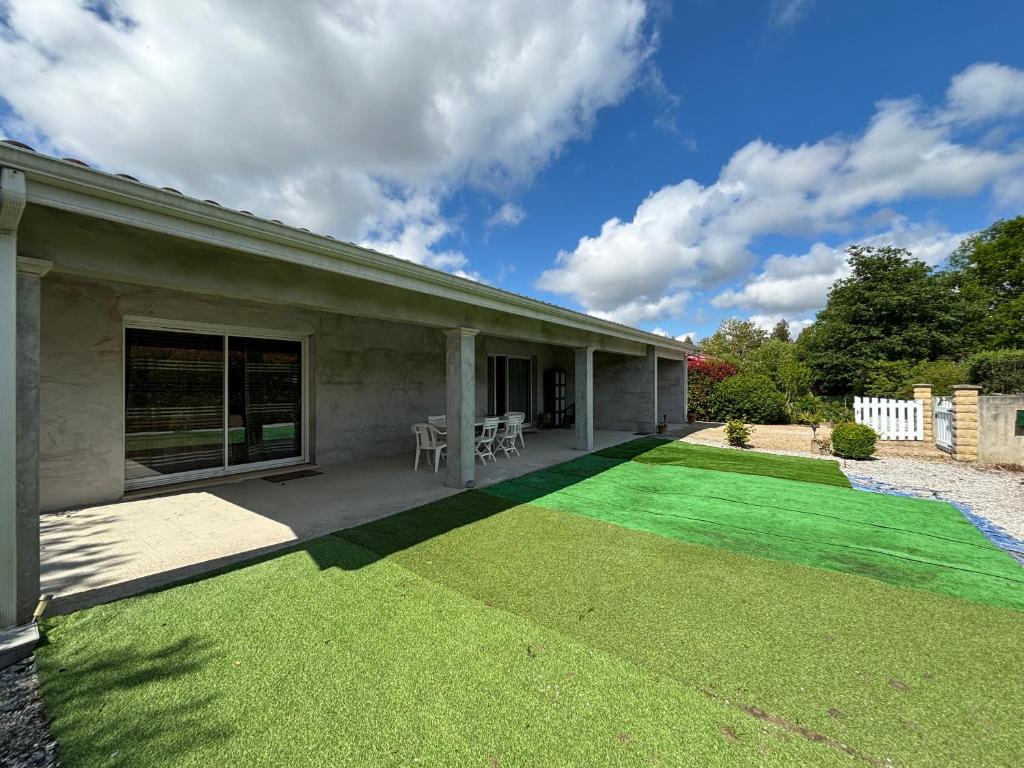 une maison avec une cour d'herbe verte dans l'établissement La Rose des Vents, à Saint-Paul-en-Born