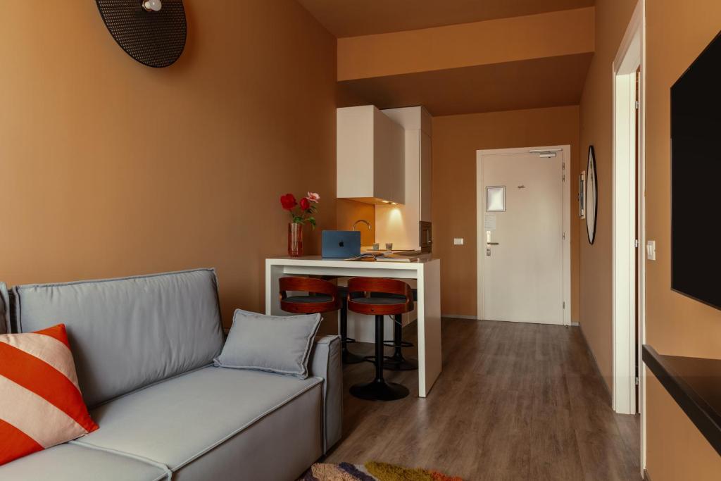 a living room with a couch and a kitchen at Bob W Ticinese in Milan