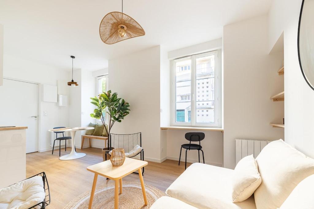 un salon avec un canapé blanc et une table dans l'établissement Darbefeuille, grand studio centre ville 2 personnes, à Nantes