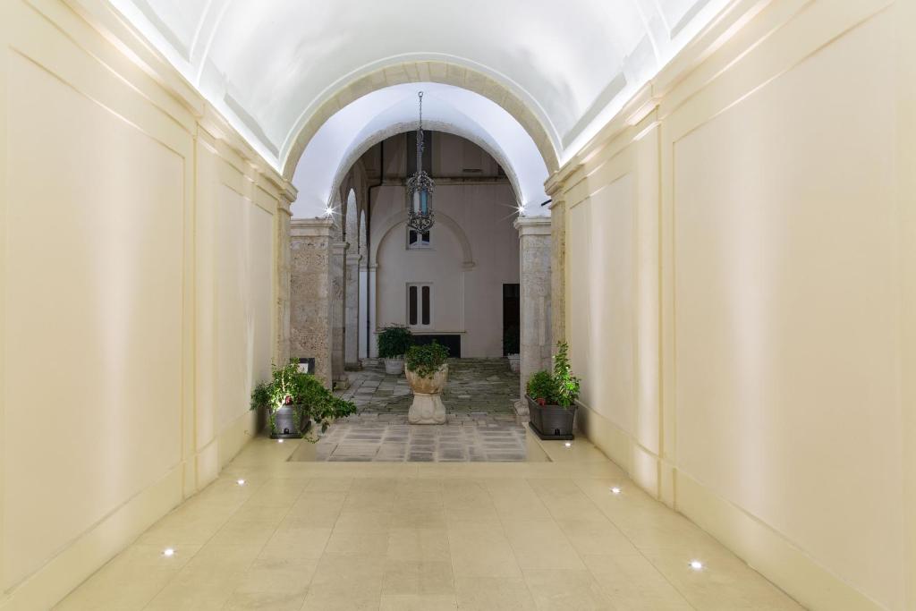 an empty hallway in a building with potted plants at Palazzo Di Paola - Residenza Storica in LʼAquila