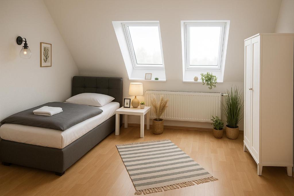 a small bedroom with a bed and two windows at SUNNYHOME Monteurwohnungen und Apartments nahe Regensburg in Nittendorf