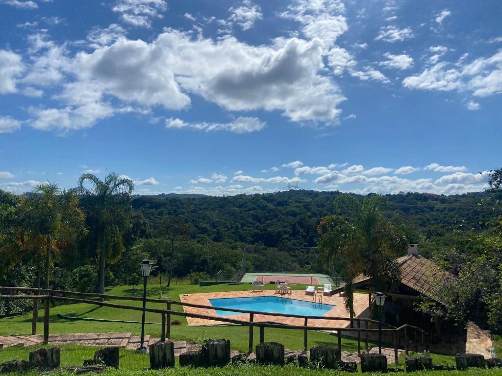 a view of a swimming pool in a field at Paraíso rural em Sousas com piscina e quadra in Campinas