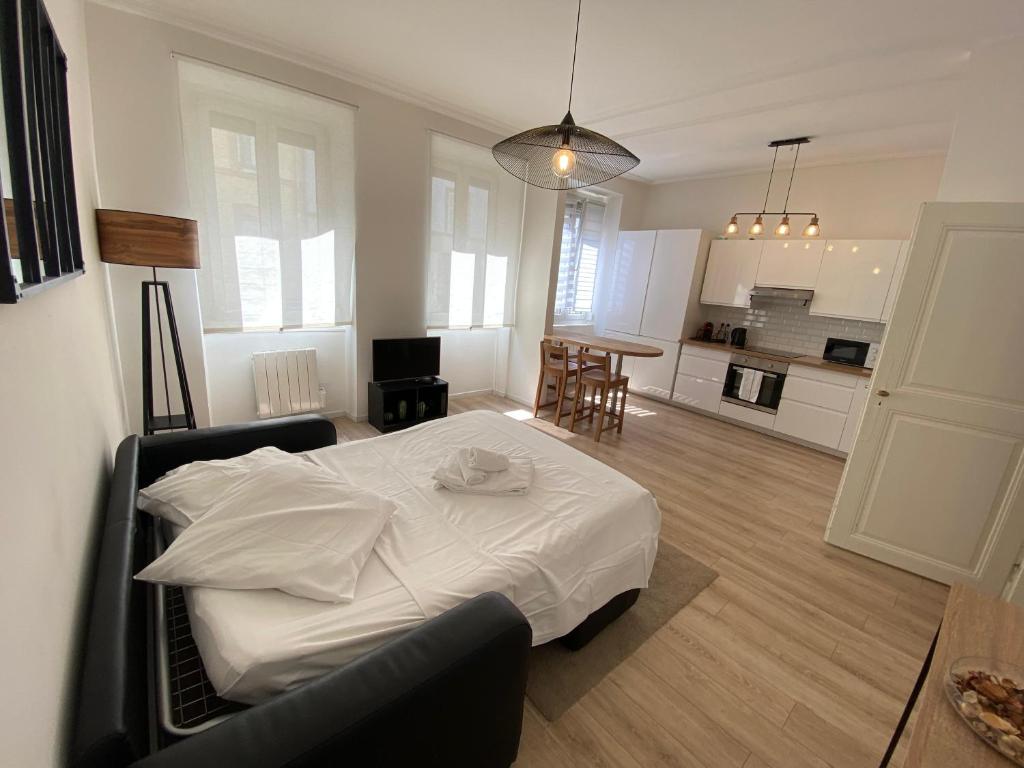 een slaapkamer met een wit bed en een keuken bij Cosy Appartement 48m Strasbourg Centre et Gare à Pied Proche Musée d Art Moderne Wifi 4 Personnes in Straatsburg