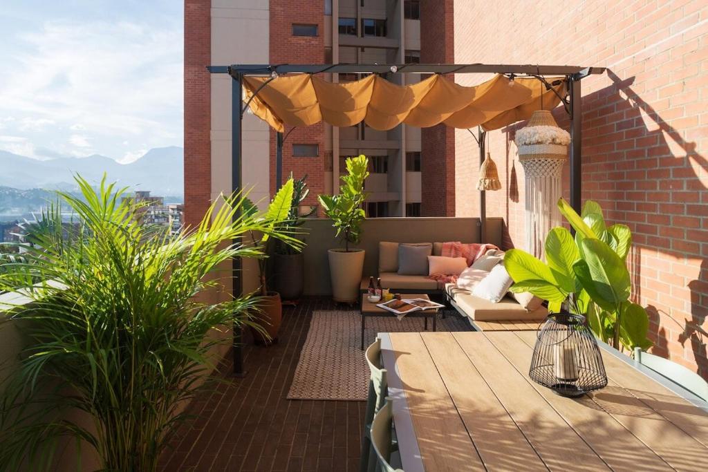 an outdoor patio with a table and an umbrella at Private Terrace Duplex in El Poblado in Medellín