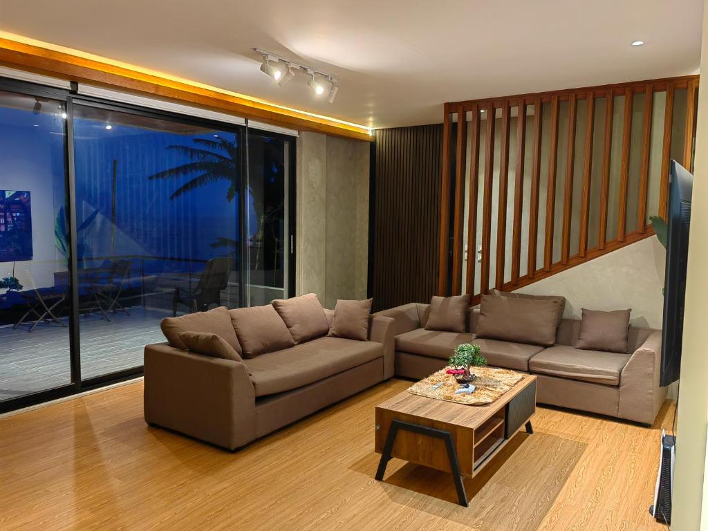 a living room with a couch and a table at The LakeFront Villa in Binangonan