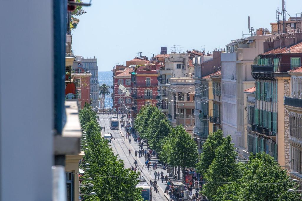 uma vista para uma rua da cidade com árvores e edifícios em Hotel 64 Nice em Nice