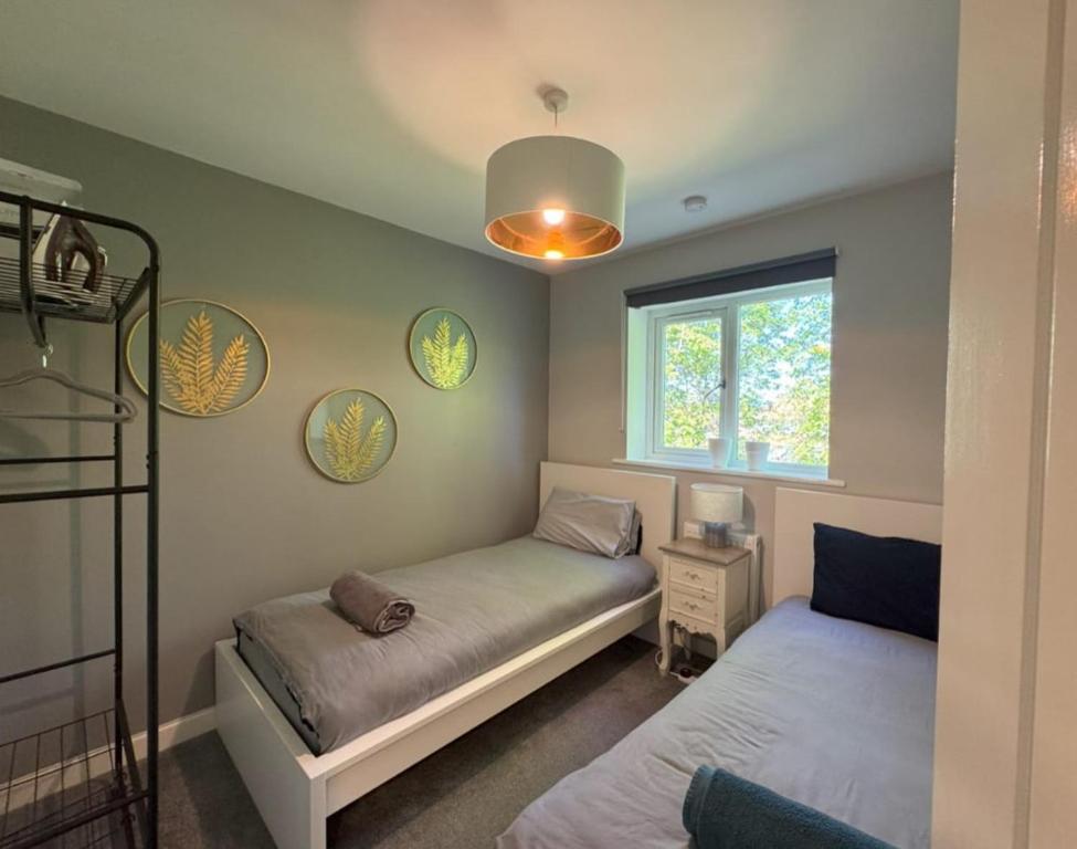a bedroom with two beds and a window at Stylish 5BR Townhouse in Manor