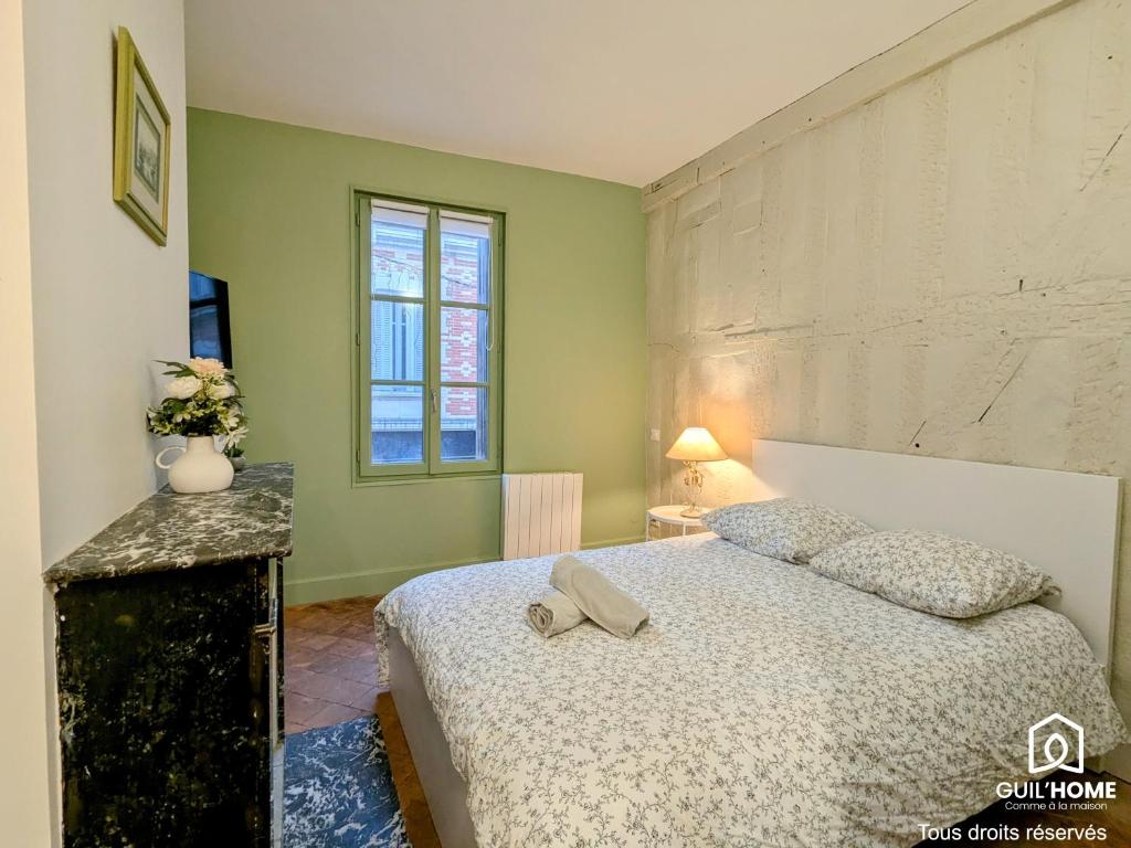 une chambre avec un lit avec un chapeau dessus dans l'établissement Le Bourgogne - Chambres privées cosy et rénovées avec douche - Centre historique, à Orléans
