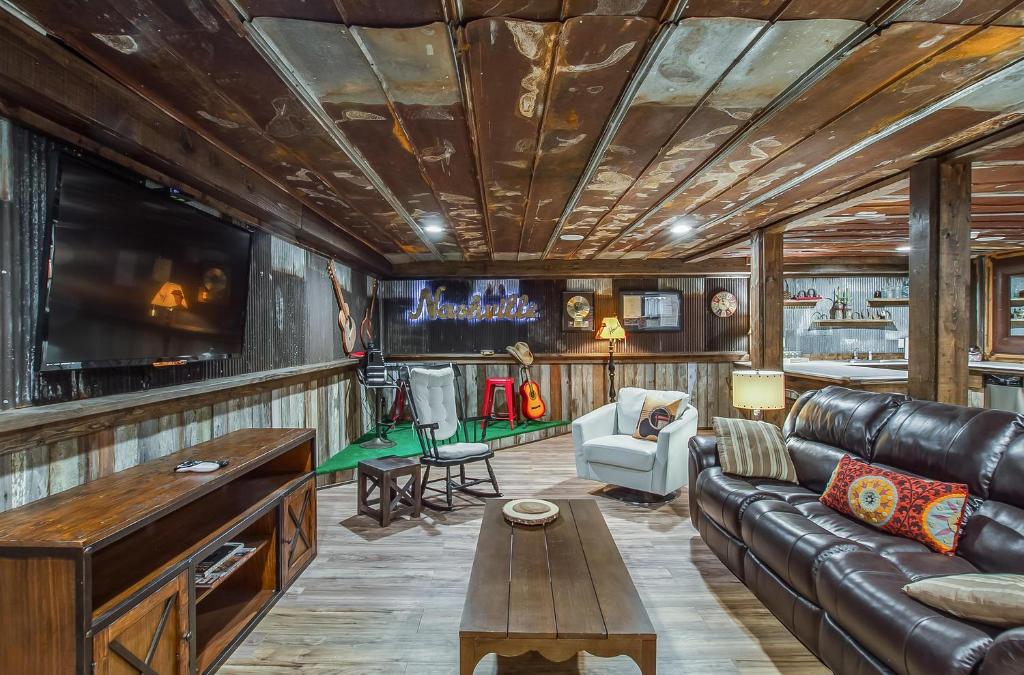 a living room with a leather couch and a tv at The Graycroft by Stay Local Nashville in Nashville