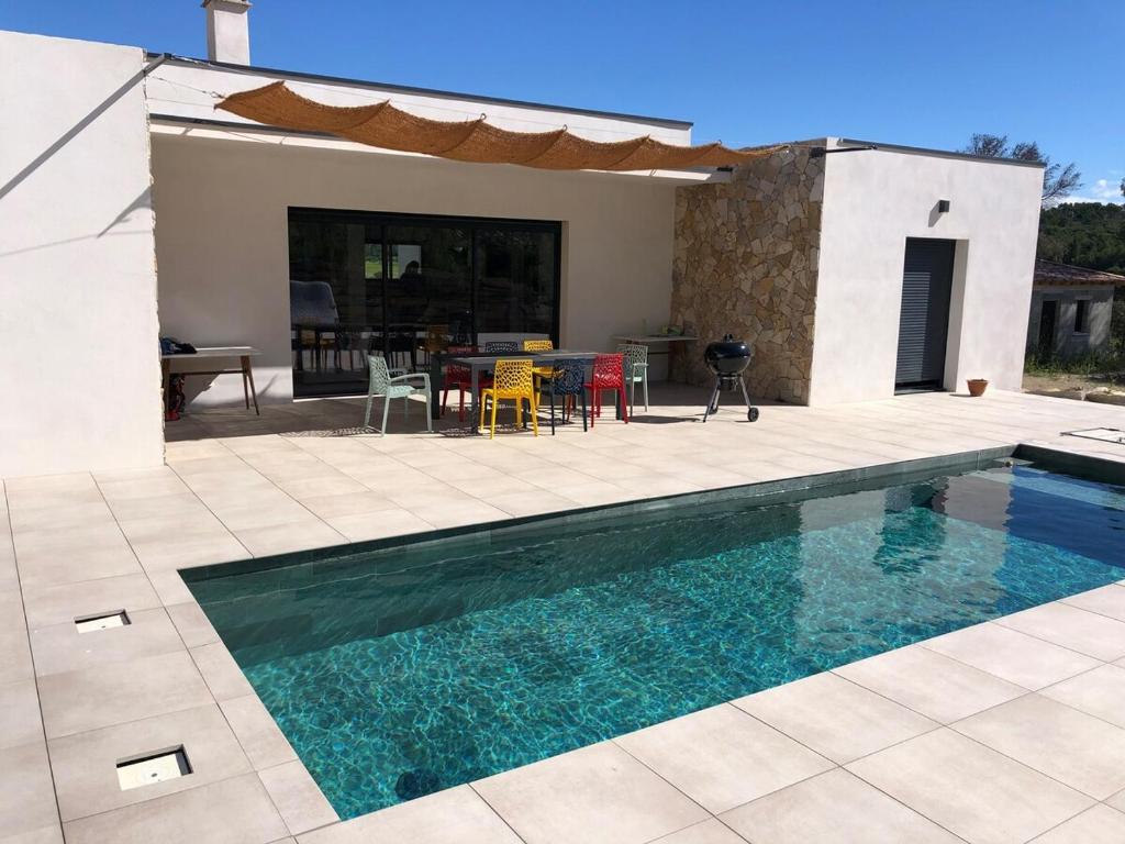 Cette maison dispose d'une piscine et d'une terrasse avec une table. dans l'établissement Villa with pool for 8 people, à Boissières