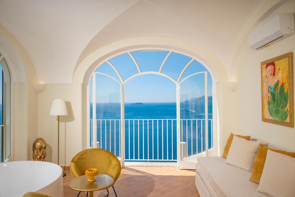 a living room with a large window and a couch at Villa Santa Chiara Positano Suites in Positano